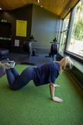 A blond woman doing a push up at the gym. She is wearing a blue sports bra and matching Sleek Tights from Björn Borg